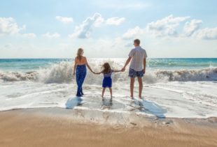 Image d'illustration représentant une famille qui a les pieds dans l'eau sur la plage