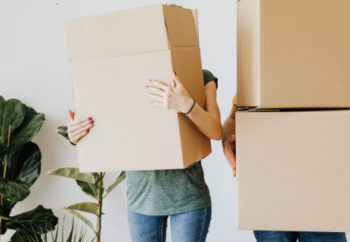 photographie mettant en scène un couple en train de porter des cartons pour leur emménagement
